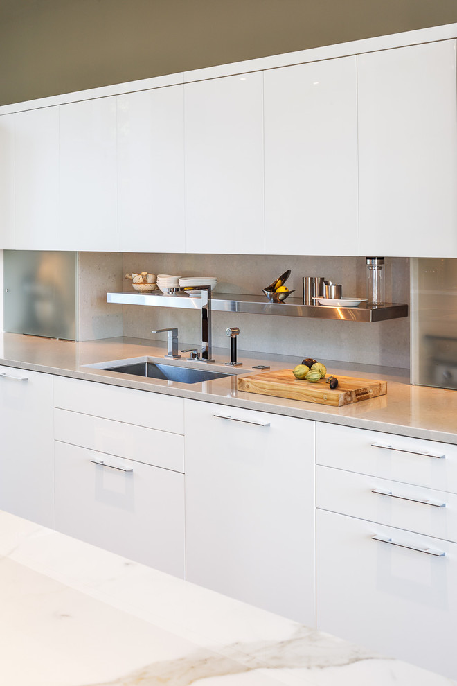 Large contemporary galley eat-in kitchen in Ottawa with an undermount sink, flat-panel cabinets, white cabinets, wood benchtops, grey splashback, stone slab splashback, stainless steel appliances, light hardwood floors and with island.