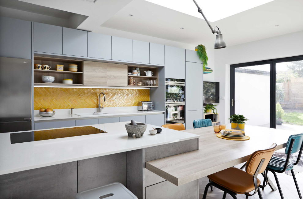 Large contemporary eat-in kitchen in Surrey with flat-panel cabinets, grey cabinets, quartzite benchtops, yellow splashback, ceramic splashback, with island and white benchtop.
