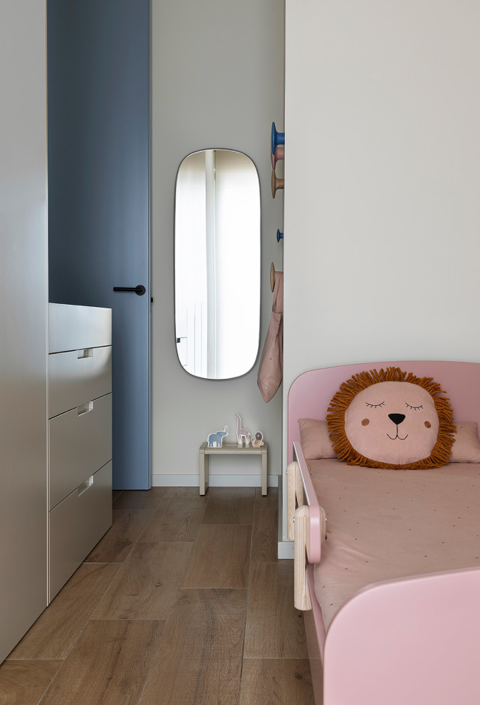Imagen de dormitorio infantil de 4 a 10 años y abovedado actual de tamaño medio con paredes beige, suelo de madera en tonos medios y suelo marrón