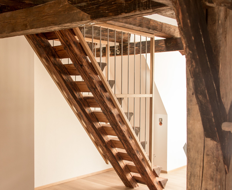 This is an example of a small country wood straight staircase in Stuttgart with metal railing.