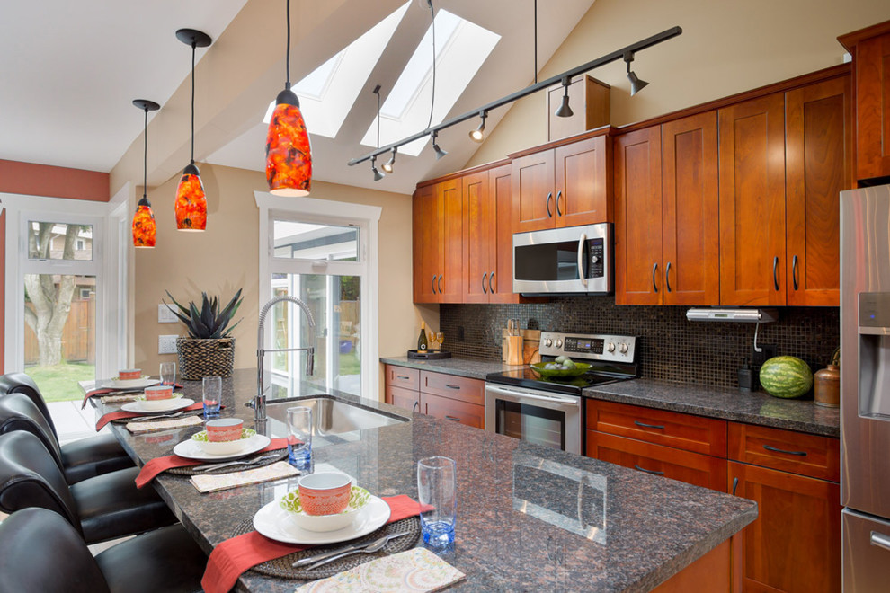 Mid-sized transitional galley eat-in kitchen photo in Toronto with an undermount sink, beaded inset cabinets, medium tone wood cabinets, granite countertops, multicolored backsplash, stainless steel appliances and an island
