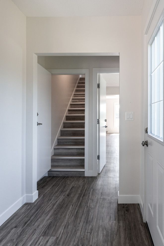 Inspiration for a mid-sized traditional hallway in Edmonton with grey walls, vinyl floors and brown floor.