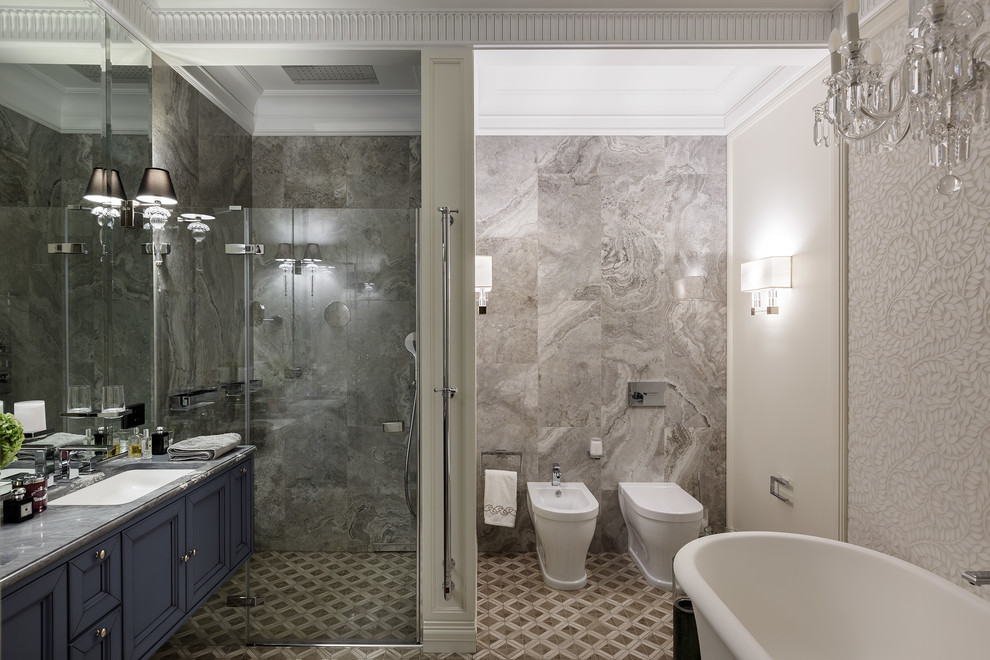Photo of a mid-sized transitional master bathroom in Saint Petersburg with recessed-panel cabinets, blue cabinets, a curbless shower, a bidet, gray tile, mosaic tile floors, marble benchtops, multi-coloured floor, a hinged shower door, an undermount sink, marble and multi-coloured walls.
