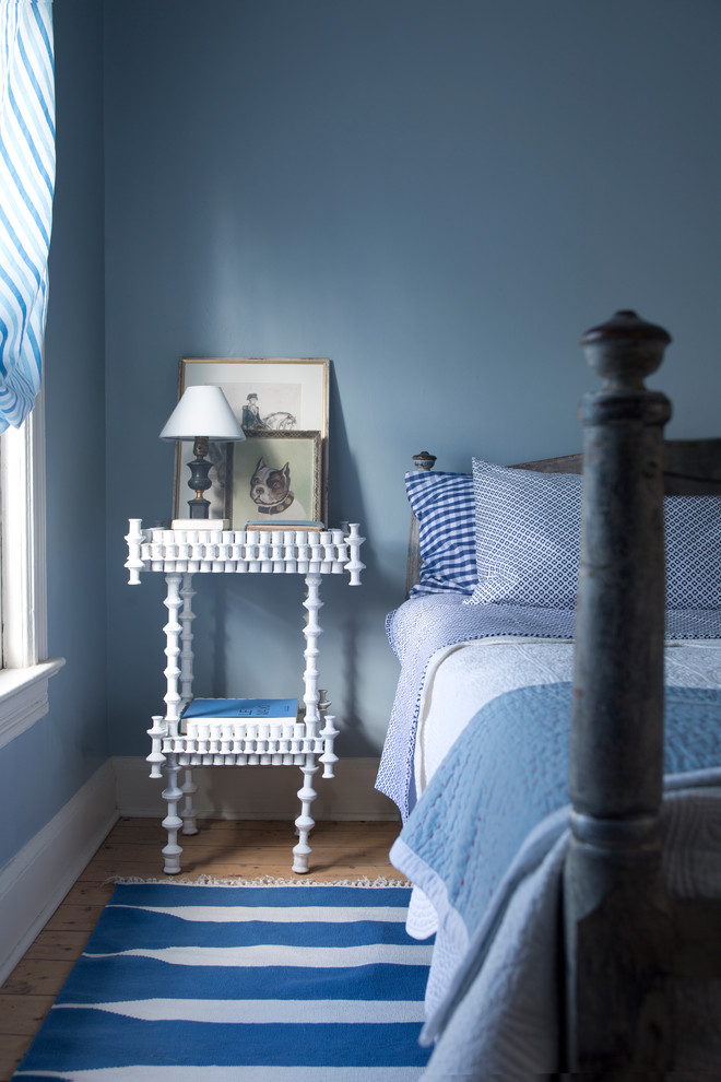 Photo of a traditional bedroom in Vancouver with blue walls and light hardwood floors.