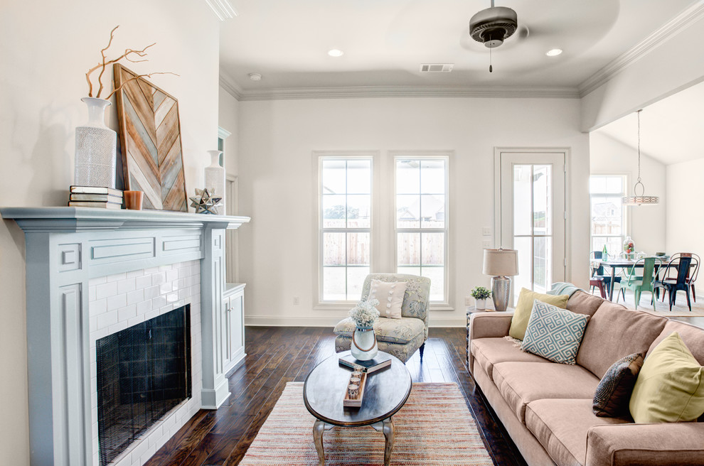 This is an example of a mid-sized transitional formal open concept living room in New Orleans with white walls, medium hardwood floors, a standard fireplace, a tile fireplace surround, no tv and brown floor.