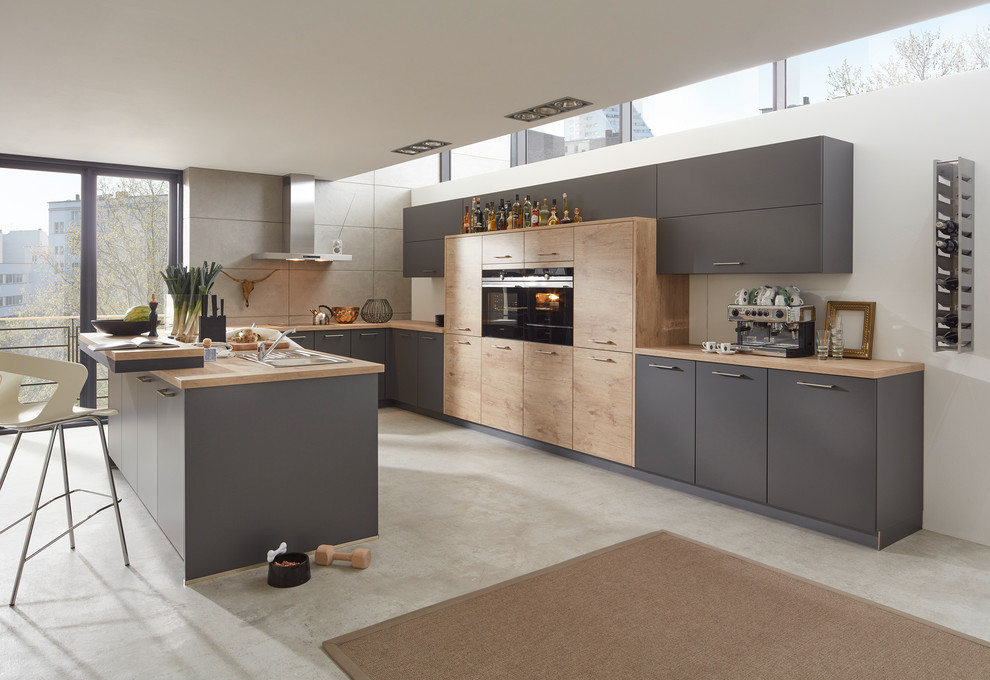 Photo of a mid-sized contemporary u-shaped kitchen in Dusseldorf with grey cabinets, white splashback, black appliances and a peninsula.