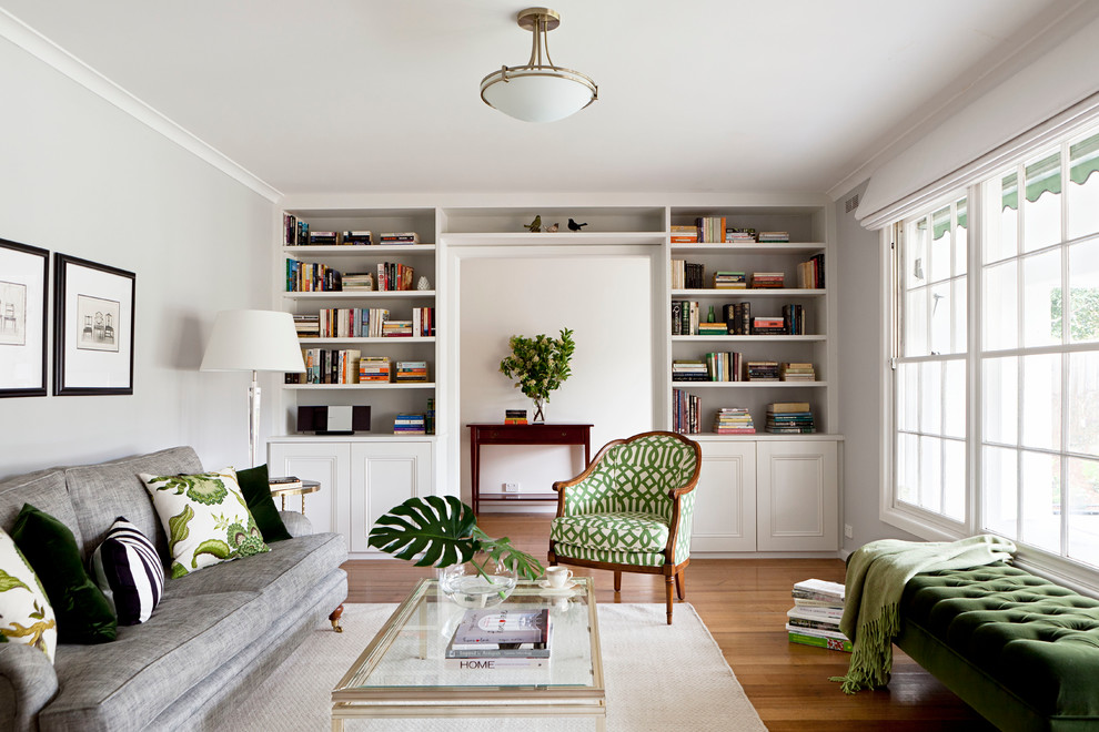 Photo of a mid-sized transitional enclosed living room in Melbourne with a library, grey walls, medium hardwood floors, no fireplace and no tv.
