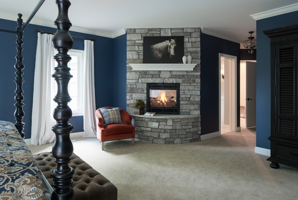 Design ideas for a large traditional master bedroom in Minneapolis with blue walls, carpet, a two-sided fireplace, a stone fireplace surround and beige floor.