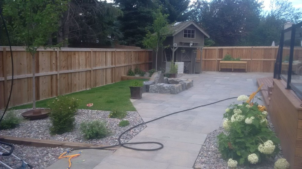 Design ideas for a mid-sized transitional backyard partial sun garden in Calgary with natural stone pavers.