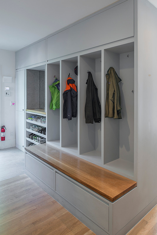 This is an example of a modern mudroom in New York with grey walls and light hardwood floors.