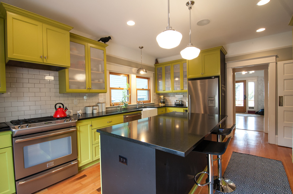 Photo of an eclectic kitchen in Portland with subway tile splashback, a farmhouse sink and green cabinets.