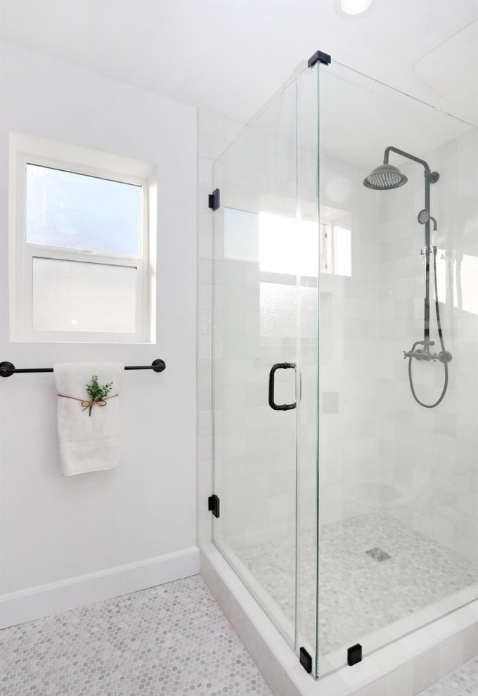 Пример оригинального дизайна: ванная комната в средиземноморском стиле с фасадами с декоративным кантом, синими фасадами, душем в нише, унитазом-моноблоком, серой плиткой, плиткой из листового стекла, белыми стенами, полом из мозаичной плитки, врезной раковиной, столешницей из искусственного кварца, белым полом, душем с распашными дверями, белой столешницей, нишей, тумбой под две раковины и встроенной тумбой