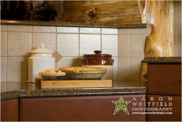 Example of a mid-sized mountain style terra-cotta tile open concept kitchen design with shaker cabinets, quartz countertops and stainless steel appliances