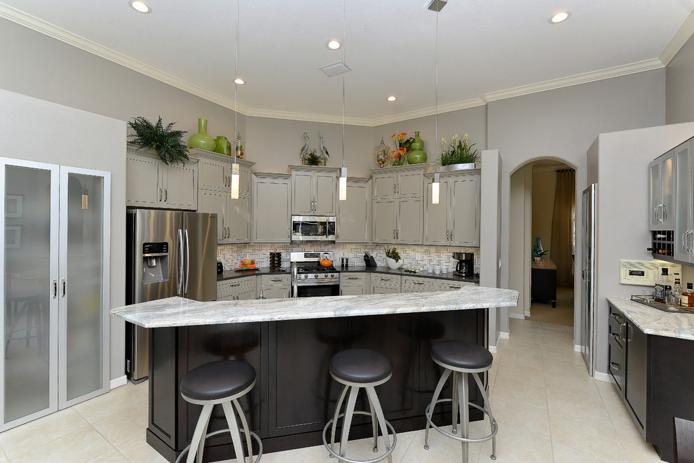 Mid-sized transitional u-shaped eat-in kitchen in Tampa with stainless steel appliances, with island, a double-bowl sink, beaded inset cabinets, grey cabinets, marble benchtops, grey splashback, matchstick tile splashback and ceramic floors.