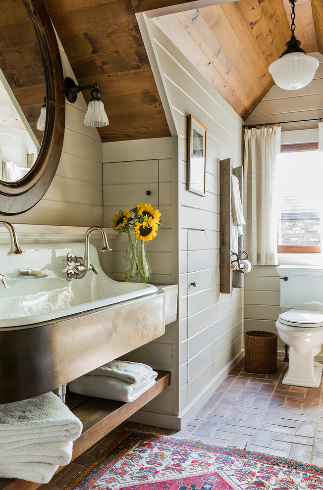Photo of a mid-sized country bathroom in Boston with a trough sink and brick floors.