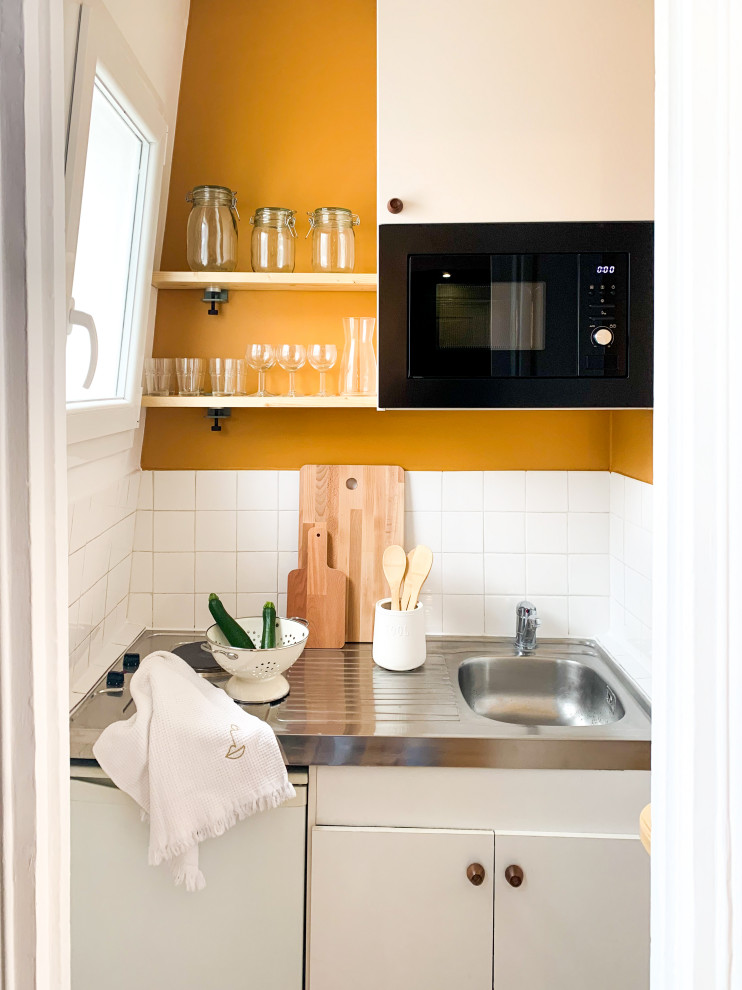 Kleine Moderne Küche mit Unterbauwaschbecken, Küchenrückwand in Gelb, Rückwand aus Keramikfliesen und Zementfliesen für Boden in Paris