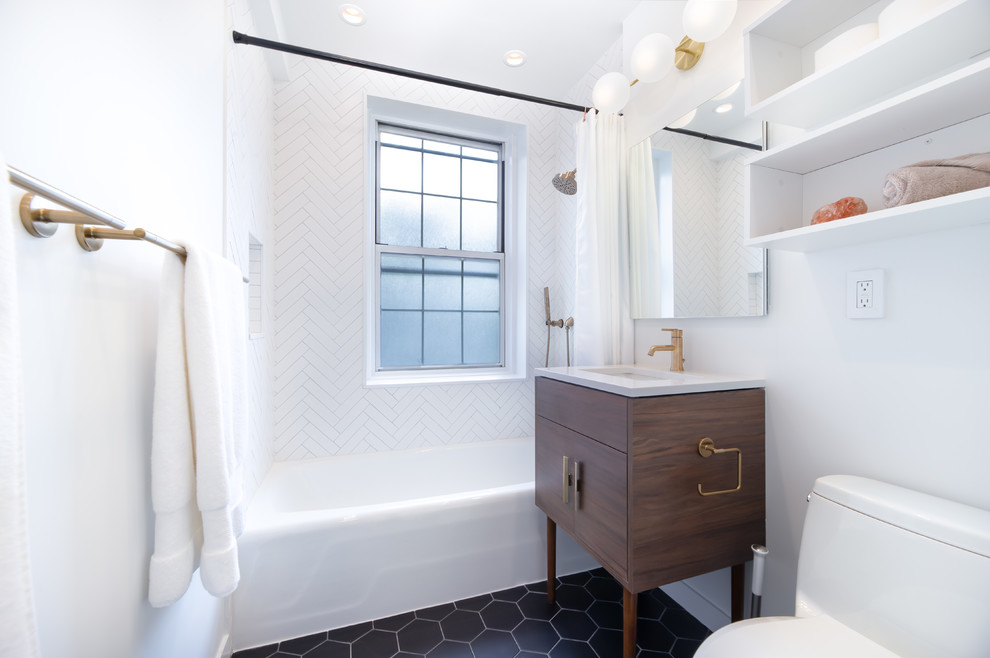 Photo of a contemporary bathroom in New York with flat-panel cabinets, dark wood cabinets, an alcove tub, a shower/bathtub combo, white tile, white walls, an undermount sink, black floor, a shower curtain and white benchtops.