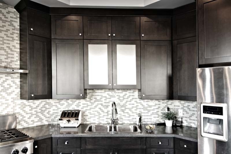 Inspiration for a mid-sized transitional l-shaped eat-in kitchen in Calgary with a double-bowl sink, shaker cabinets, dark wood cabinets, granite benchtops, multi-coloured splashback, matchstick tile splashback, stainless steel appliances, porcelain floors, with island and grey floor.
