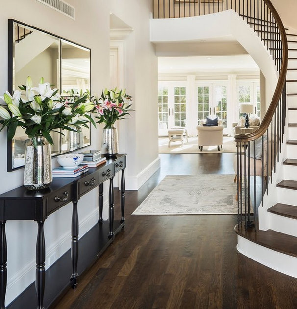 Photo of a large transitional foyer in New York with white walls, medium hardwood floors, a double front door, a white front door and brown floor.