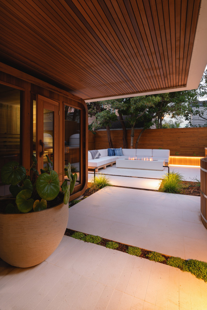 Modelo de jardín minimalista pequeño en patio trasero con brasero, exposición parcial al sol, adoquines de hormigón y con madera