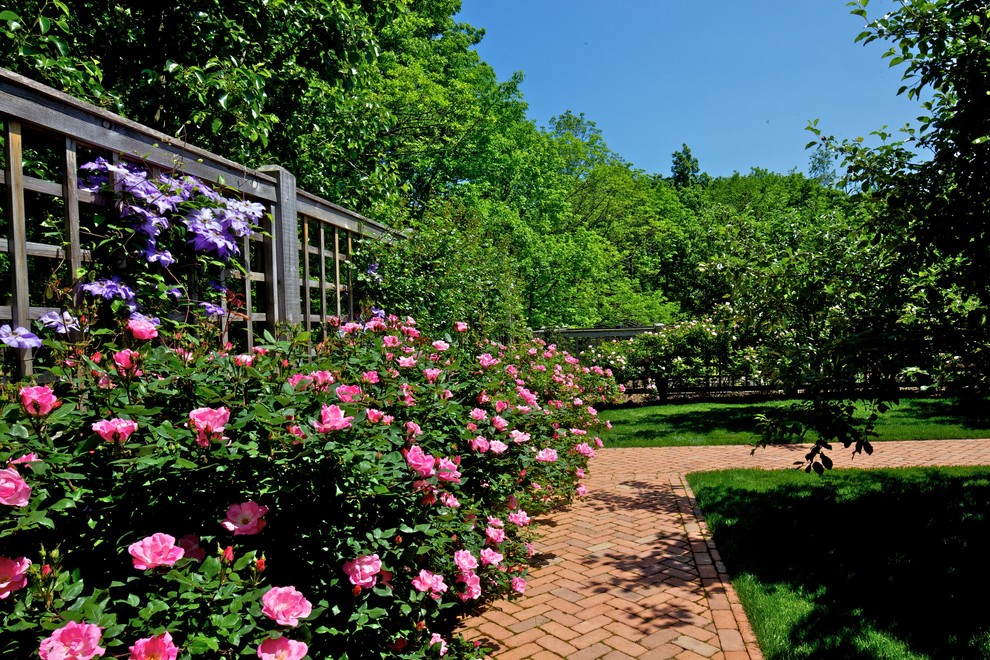 Photo of a large traditional backyard full sun formal garden for summer in New York with brick pavers and a garden path.