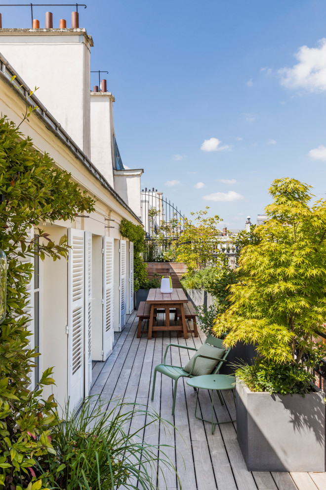 Photo of a medium sized contemporary side ground level metal railing terrace in Paris with a potted garden and no cover.