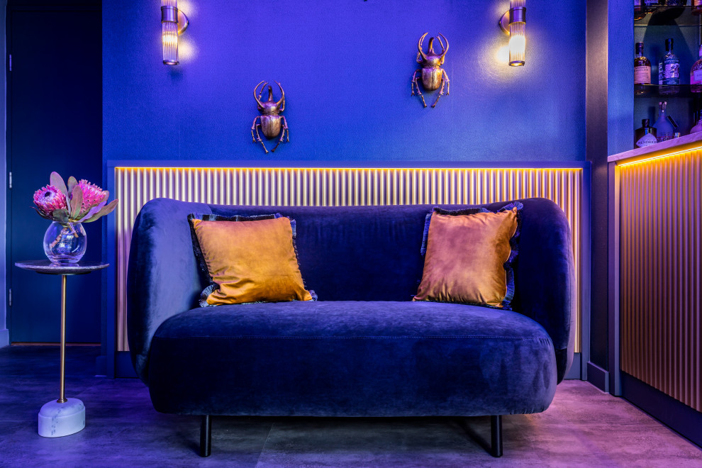 На фото: гостиная комната среднего размера:: освещение в стиле фьюжн с домашним баром, синими стенами, полом из винила, телевизором на стене, коричневым полом и панелями на части стены