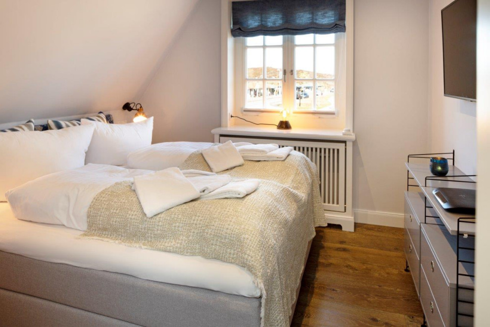 Kleines Stilmix Gästezimmer mit grauer Wandfarbe und gebeiztem Holzboden in Sonstige