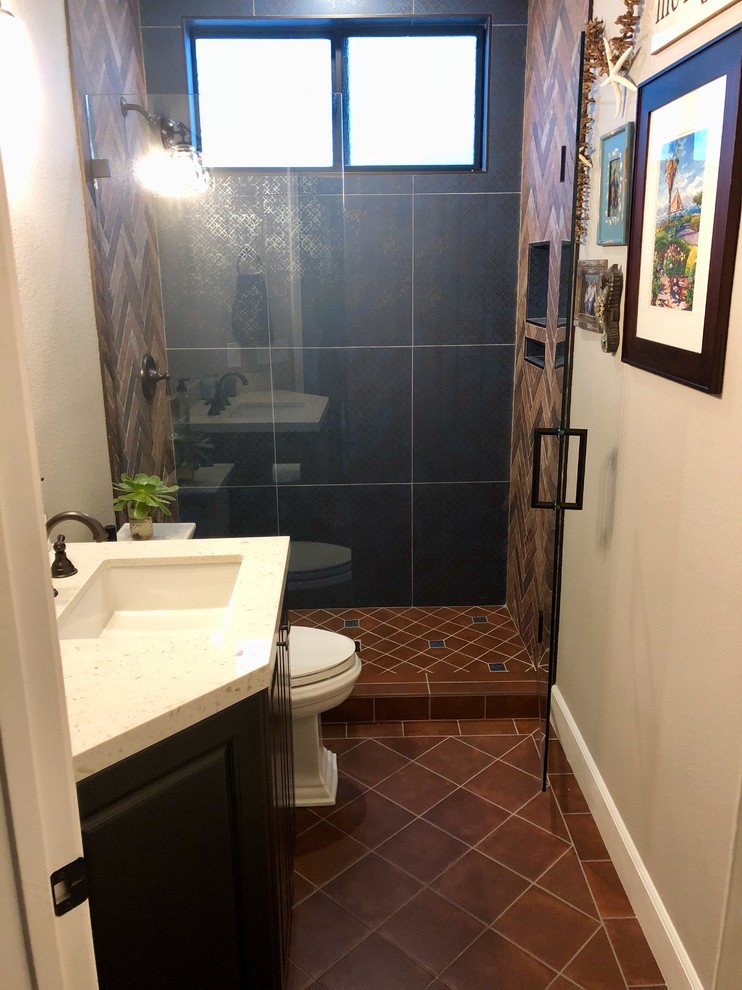This is an example of a small country 3/4 bathroom in San Diego with recessed-panel cabinets, brown cabinets, an open shower, a two-piece toilet, blue tile, terra-cotta tile, beige walls, terra-cotta floors, an undermount sink, red floor and a hinged shower door.