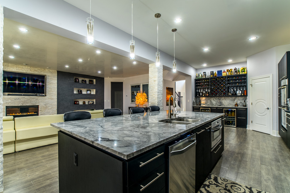 Photo of an expansive modern single-wall kitchen pantry in Charleston with a double-bowl sink, flat-panel cabinets, black cabinets, marble benchtops, grey splashback, glass tile splashback, stainless steel appliances, ceramic floors and with island.