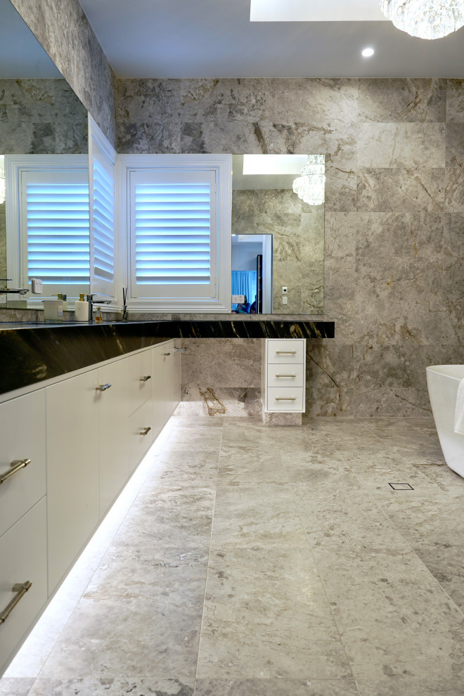 Expansive modern master bathroom in Sydney with flat-panel cabinets, white cabinets, a freestanding tub, multi-coloured tile, marble, an undermount sink, marble benchtops, black benchtops, a single vanity and a built-in vanity.