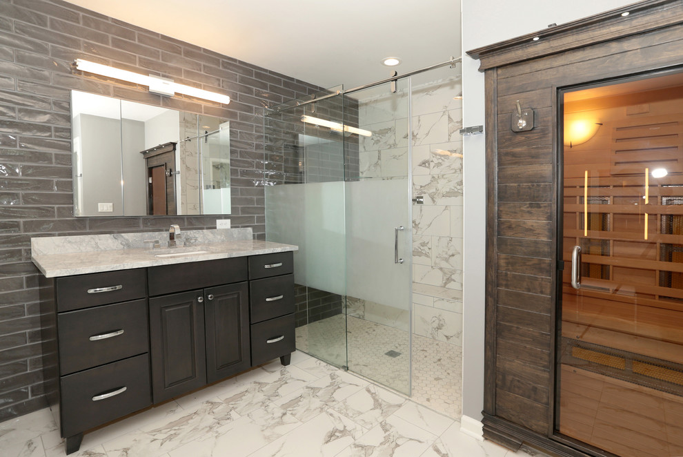 Example of a large transitional gray tile and subway tile porcelain tile and white floor freestanding bathtub design with raised-panel cabinets, gray cabinets, gray walls, an undermount sink and granite countertops