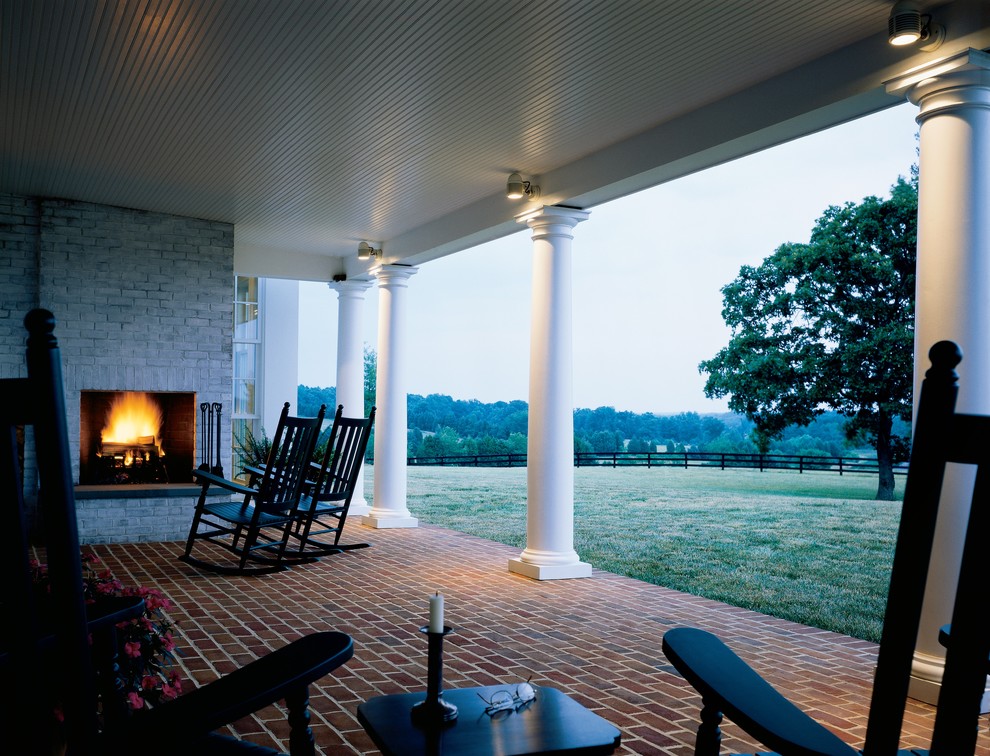 Photo of a country patio in Richmond with a fire feature, brick pavers and a roof extension.