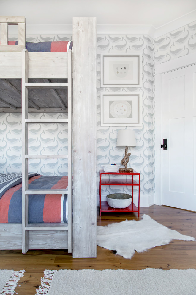 Design ideas for an expansive beach style gender-neutral kids' bedroom for kids 4-10 years old in New York with white walls and medium hardwood floors.