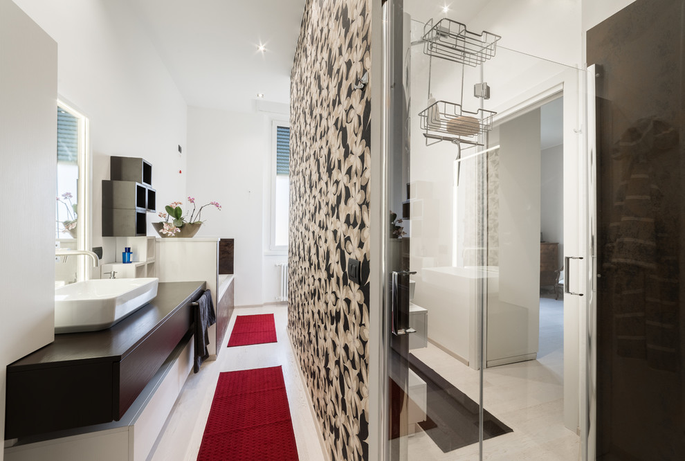 This is an example of a mid-sized contemporary 3/4 bathroom in Milan with flat-panel cabinets, medium wood cabinets, a drop-in tub, a corner shower, a wall-mount toilet, white walls, light hardwood floors, a vessel sink and wood benchtops.