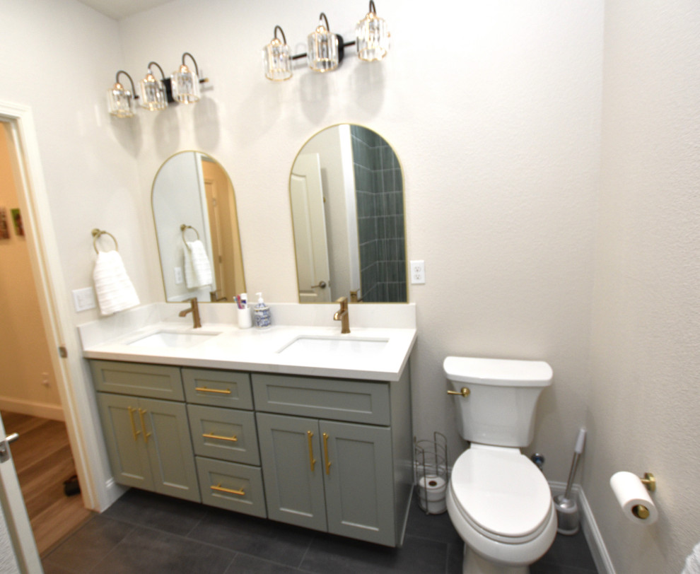 Mid-sized transitional green tile and porcelain tile vinyl floor, gray floor and double-sink alcove bathtub photo with shaker cabinets, green cabinets, an undermount sink, solid surface countertops, white countertops and a built-in vanity