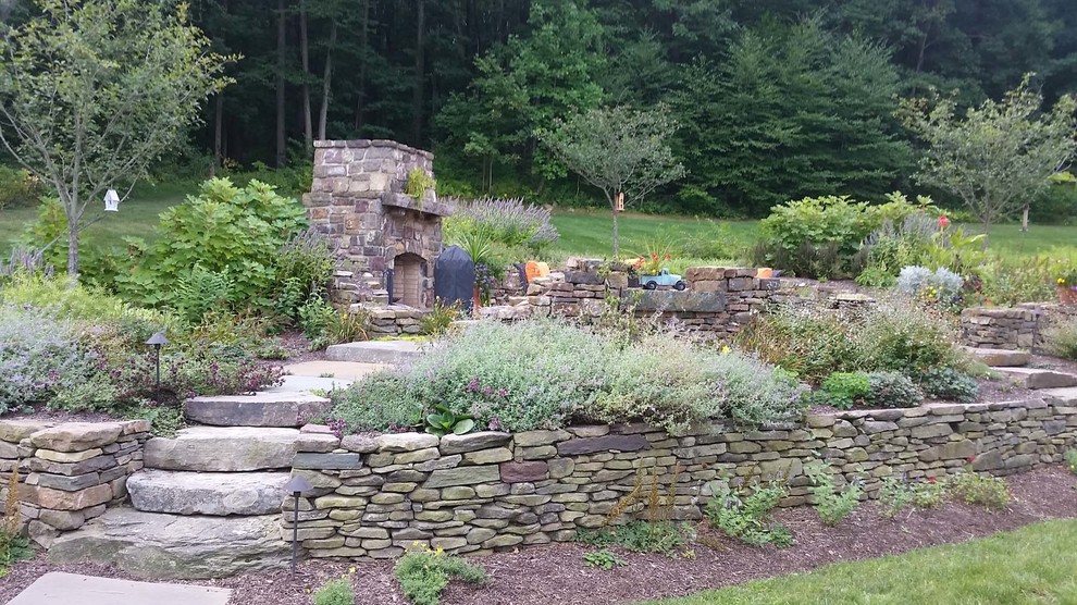 This is an example of a country backyard garden in Philadelphia with natural stone pavers.