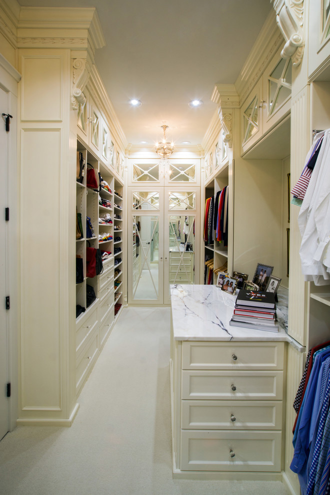 Inspiration for a large transitional gender-neutral walk-in wardrobe in Charlotte with recessed-panel cabinets, white cabinets, carpet and white floor.