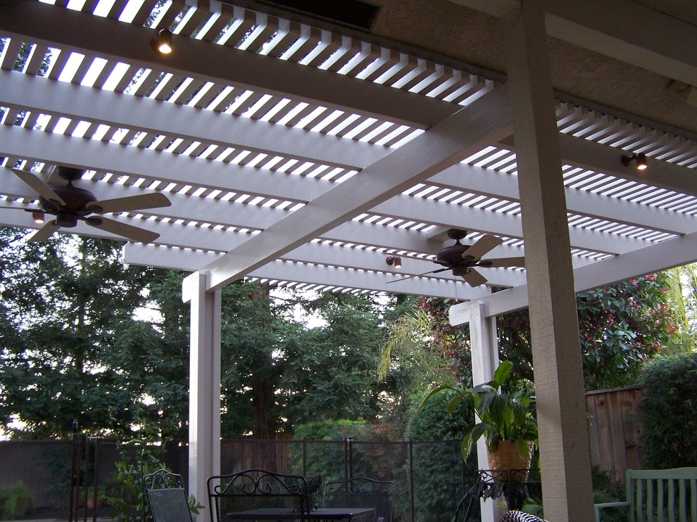 Mid-sized traditional backyard patio in Other with concrete slab, a pergola and an outdoor kitchen.