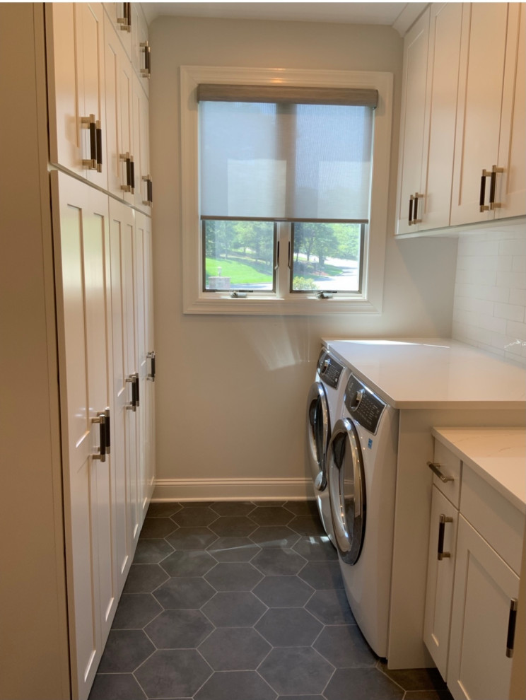 Mid-sized transitional galley dedicated laundry room in New York with an undermount sink, shaker cabinets, white cabinets, quartz benchtops, white splashback, ceramic splashback, grey walls, ceramic floors, an integrated washer and dryer, grey floor and white benchtop.