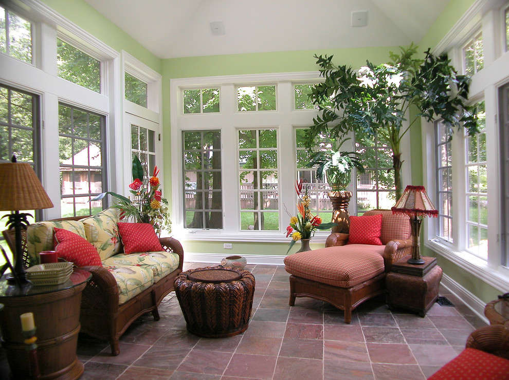 This is an example of a mid-sized tropical sunroom in Chicago with slate floors, a standard ceiling and brown floor.