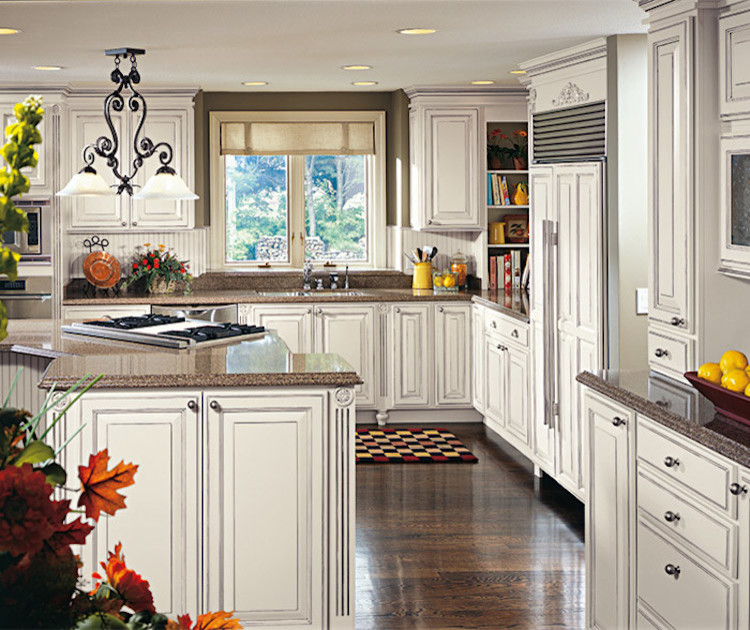 Example of a mid-sized transitional l-shaped brown floor and dark wood floor eat-in kitchen design in Orange County with an undermount sink, raised-panel cabinets, white cabinets, granite countertops, beige backsplash, ceramic backsplash, stainless steel appliances and an island