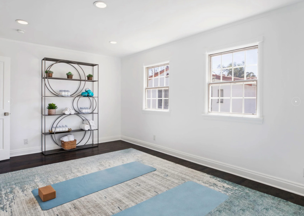Mittelgroßer Klassischer Yogaraum mit weißer Wandfarbe, dunklem Holzboden und braunem Boden in Los Angeles