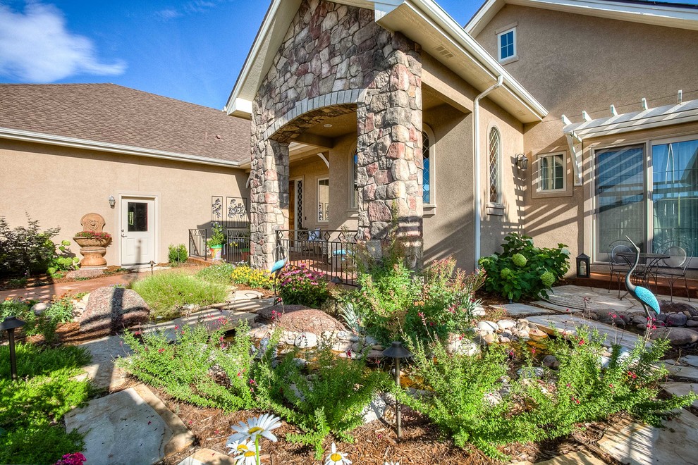 This is an example of a mid-sized transitional partial sun front yard stone walkway in Denver.
