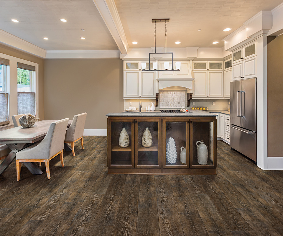 Inspiration for a transitional u-shaped light wood floor and beige floor enclosed kitchen remodel in Orlando with an undermount sink, flat-panel cabinets, dark wood cabinets, granite countertops, white backsplash, subway tile backsplash, stainless steel appliances and an island