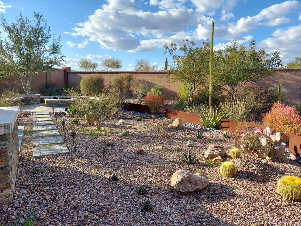 Mid-sized and desert look modern backyard full sun xeriscape in Milwaukee with concrete pavers for summer.