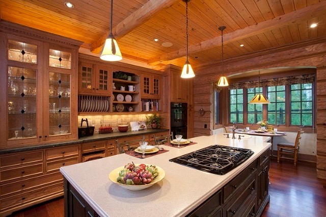Eat-in kitchen - large rustic medium tone wood floor and brown floor eat-in kitchen idea in Denver with an island, a drop-in sink, recessed-panel cabinets, medium tone wood cabinets, beige backsplash, stone tile backsplash, black appliances and white countertops