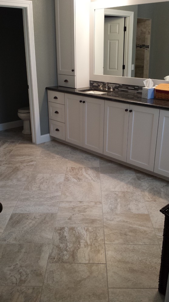 Large transitional master beige tile and porcelain tile porcelain tile bathroom photo with an undermount sink, white cabinets and granite countertops