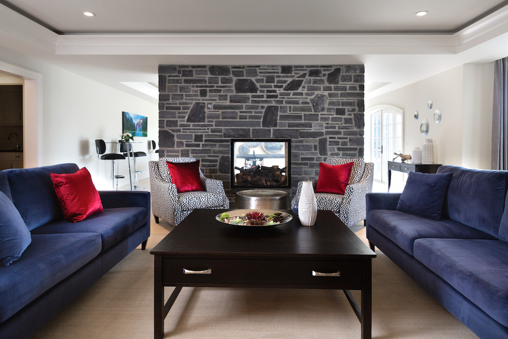 Inspiration for an expansive transitional walk-out basement in Calgary with white walls, carpet, a two-sided fireplace, a stone fireplace surround and beige floor.
