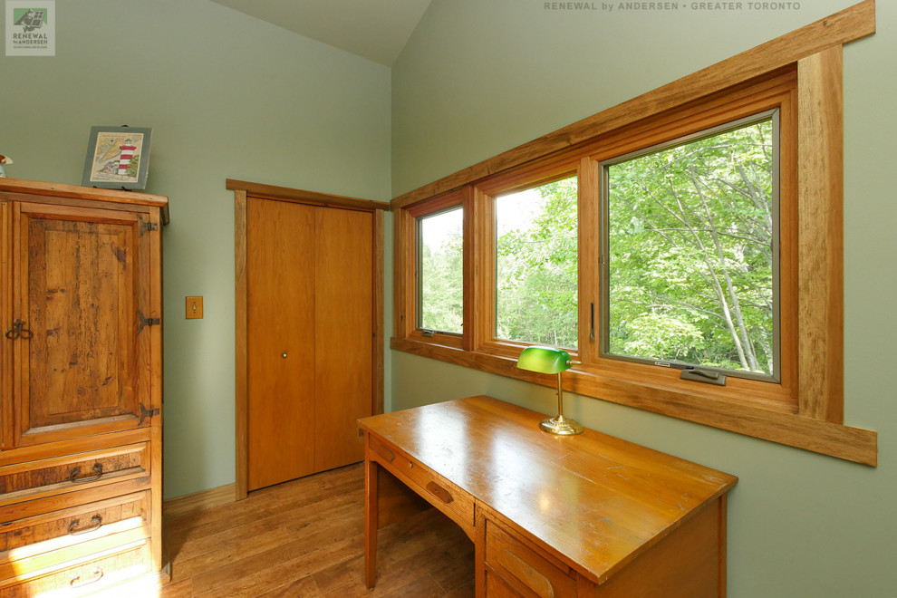 Réalisation d'un bureau de taille moyenne avec un mur vert, un sol en bois brun, aucune cheminée, un bureau indépendant et un plafond voûté.